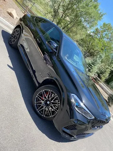 Black BMW X6 M with deep gloss paint and cleaned wheels after detailing